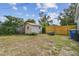 Spacious backyard with a storage shed and a wooden fence. Featuring mature landscaping and a blue sky at 1260 S Hillcrest Ave, Clearwater, FL 33756