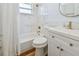 Bathroom featuring a shower-tub combo, a modern vanity with gold fixtures, and marble-tiled walls at 1260 S Hillcrest Ave, Clearwater, FL 33756