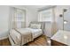 Well-lit bedroom with queen bed, window with coverings, and desk workspace at 1260 S Hillcrest Ave, Clearwater, FL 33756
