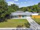 Charming single-story home with a well-manicured lawn, a covered front porch, and an attached garage at 1260 S Hillcrest Ave, Clearwater, FL 33756