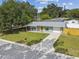 Charming single-story home with a well-manicured lawn, a covered front porch, and an attached garage at 1260 S Hillcrest Ave, Clearwater, FL 33756