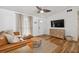 Inviting living room showcases a ceiling fan, TV, wood-look flooring, and leather couch at 1260 S Hillcrest Ave, Clearwater, FL 33756