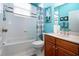 Bathroom with white tile, vanity, bathtub and shower featuring turquoise walls and natural light at 1308 Crystal Greens Dr, Sun City Center, FL 33573