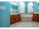 Bright bathroom with tile floors, vanity, soaking tub under arch window, and turquoise walls at 1308 Crystal Greens Dr, Sun City Center, FL 33573
