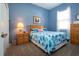 Comfortable bedroom with blue walls, queen bed, natural light from window and wood furniture at 1308 Crystal Greens Dr, Sun City Center, FL 33573