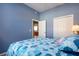 Bedroom with blue walls, bed with patterned comforter, closet, doorway, and light-filled at 1308 Crystal Greens Dr, Sun City Center, FL 33573