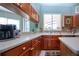 Kitchen featuring light countertops, wooden cabinets, and mosaic backsplash and open to dining area at 1308 Crystal Greens Dr, Sun City Center, FL 33573