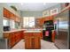 Charming kitchen with light countertops, wood cabinetry, stainless refrigerator, and breakfast bar area at 1308 Crystal Greens Dr, Sun City Center, FL 33573