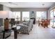 Bright living room featuring tile floors, comfortable seating, and a view of the lanai and pool area at 1308 Crystal Greens Dr, Sun City Center, FL 33573