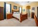 Well-lit main bedroom featuring a wooden bed frame, furniture and an ensuite bathroom at 1308 Crystal Greens Dr, Sun City Center, FL 33573