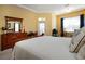 Serene main bedroom with a wooden bed frame, dresser and a comfortable seating area at 1308 Crystal Greens Dr, Sun City Center, FL 33573