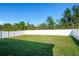 A spacious backyard featuring a lush green lawn and a tall white fence for privacy at 13355 Willow Bluestar Loop, Riverview, FL 33579
