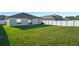 Large grassy backyard with a white fence surrounding a house with sliding glass doors at 13355 Willow Bluestar Loop, Riverview, FL 33579