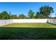 A spacious backyard featuring a lush green lawn with a tall white fence at 13355 Willow Bluestar Loop, Riverview, FL 33579