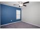 Cozy bedroom featuring carpeted floors, a ceiling fan, and a bright blue accent wall at 13355 Willow Bluestar Loop, Riverview, FL 33579