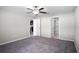 Neutral bedroom with carpet flooring, a ceiling fan, and doorways leading to the kitchen and bathroom at 13355 Willow Bluestar Loop, Riverview, FL 33579