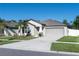 Single-story home with a gray exterior, a two-car garage, and a concrete driveway with landscaped yard at 13355 Willow Bluestar Loop, Riverview, FL 33579