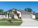 Well-maintained single-story home with a neat lawn, gray garage door, and freshly planted landscaping at 13355 Willow Bluestar Loop, Riverview, FL 33579
