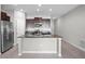 Open-concept kitchen with stainless steel appliances, granite countertops, and a large island with a sink at 13355 Willow Bluestar Loop, Riverview, FL 33579