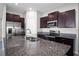 Close-up of a kitchen island featuring granite countertops, a stainless steel sink, and dark wood cabinets at 13355 Willow Bluestar Loop, Riverview, FL 33579