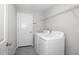 Laundry room featuring modern machines, tile floors, shelving, and access door at 13355 Willow Bluestar Loop, Riverview, FL 33579
