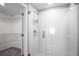 Modern glass-enclosed shower with white tile and chrome fixtures, adjacent to a walk-in closet at 13355 Willow Bluestar Loop, Riverview, FL 33579