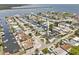 Aerial view of property showcasing waterfront location, boat dock, lush landscaping, and surrounding neighborhood at 13701 Garris Dr, Hudson, FL 34667