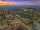 Stunning aerial view of waterfront community at sunset with canals, boat docks, and beautiful sunset at 13701 Garris Dr, Hudson, FL 34667