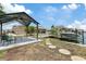Waterfront backyard featuring a boat dock, steeping stones, and a covered patio area for outdoor enjoyment at 13701 Garris Dr, Hudson, FL 34667