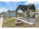 Charming backyard featuring a covered patio, fire pit, shed, and privacy fence for outdoor gatherings and relaxation at 13701 Garris Dr, Hudson, FL 34667