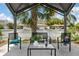 Comfortable backyard patio featuring seating, a table, and a view of the well-maintained surrounding neighborhood at 13701 Garris Dr, Hudson, FL 34667