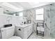 Elegant bathroom with marble walls, white vanity, and modern black fixtures at 13701 Garris Dr, Hudson, FL 34667