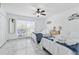 Bright bedroom featuring twin beds, white linens, ceiling fan, and serene view at 13701 Garris Dr, Hudson, FL 34667