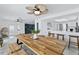 Open-concept dining room featuring a large table, decorative ceiling fan, and access to the modern kitchen at 13701 Garris Dr, Hudson, FL 34667