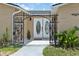 Charming entryway featuring decorative iron gate and well maintained plants at 13701 Garris Dr, Hudson, FL 34667