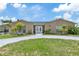 Charming single-story home featuring a circular driveway, decorative front door, and mature landscaping at 13701 Garris Dr, Hudson, FL 34667