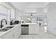 Bright kitchen with marble floors, stainless steel appliances, white cabinetry and a breakfast bar at 13701 Garris Dr, Hudson, FL 34667