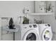Modern laundry room with front-load washer, dryer, ironing board and plants at 13701 Garris Dr, Hudson, FL 34667