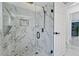 Luxurious walk-in shower with marble tile, rainfall showerhead, and glass door at 13701 Garris Dr, Hudson, FL 34667