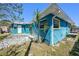 Exterior of the home with bright blue siding and a concrete patio at 14040 Miramar Ave, Madeira Beach, FL 33708
