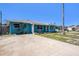 Attractive single-story home featuring a blue exterior, a well-kept driveway, and mature trees at 14040 Miramar Ave, Madeira Beach, FL 33708