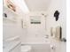 Bright bathroom featuring a shower and tub combination, white tile, and open shelving at 14173 90Th Ave, Seminole, FL 33776