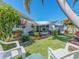 Charming home exterior featuring well-manicured landscaping, palm trees, and inviting outdoor seating at 14173 90Th Ave, Seminole, FL 33776