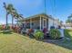 View of the home's exterior and screened-in lanai, enhanced by colorful landscaping and palm trees at 14173 90Th Ave, Seminole, FL 33776