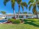 Inviting single-story home with lush landscaping and mature palm trees creating a tropical ambiance at 14173 90Th Ave, Seminole, FL 33776