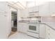 Kitchen featuring white cabinets, gray counters and access to garage with laundry area at 14173 90Th Ave, Seminole, FL 33776