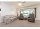 Cozy living room with a floral sofa, recliner chairs, and a large window offering outdoor views at 14173 90Th Ave, Seminole, FL 33776