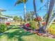 Well-maintained yard showcases lush green grass, vibrant flowers, and mature palm trees, enhancing curb appeal at 14173 90Th Ave, Seminole, FL 33776