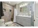 Bright bathroom features a double sink vanity and tiled shower with bench at 14924 Old Dixie Hwy, Hudson, FL 34667