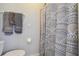 Neutral toned bathroom showcasing a patterned shower curtain, towel rack and toilet at 14924 Old Dixie Hwy, Hudson, FL 34667